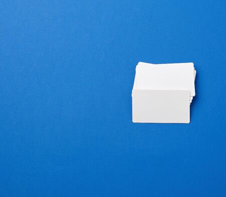 stack of rectangular white blank business cards on a blue background. Corporate business conceptの写真素材
