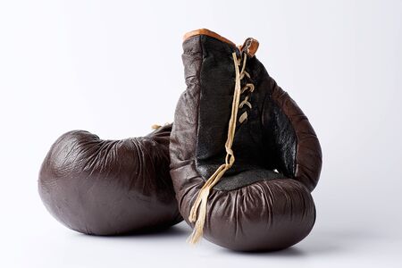 pair of vintage brown leather boxing gloves on a white background, sports equipment. Fitness gym background.の写真素材