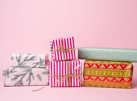 stack of colored paper wrapped gift boxes. great design for any purposes. pink background の写真素材