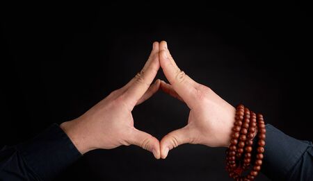 two male hands connected on a black background, demonstration of mudra soaring lotusの写真素材