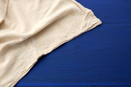 white kitchen textile towel folded on a blue wooden table from old boards, top view, empty space....