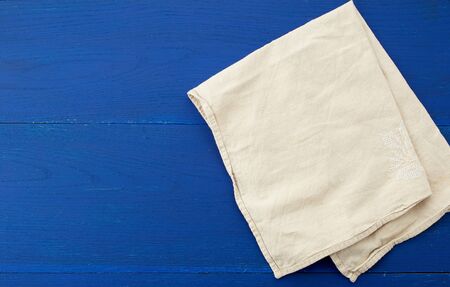white kitchen textile towel folded on a blue wooden table from old boards, top view, empty space....