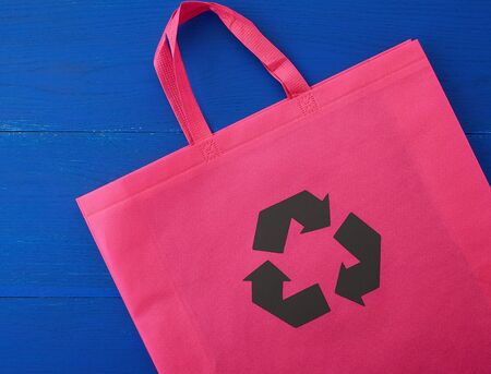 Reusable pink viscose bag on blue wooden background, plastic waste reduction conceptの写真素材