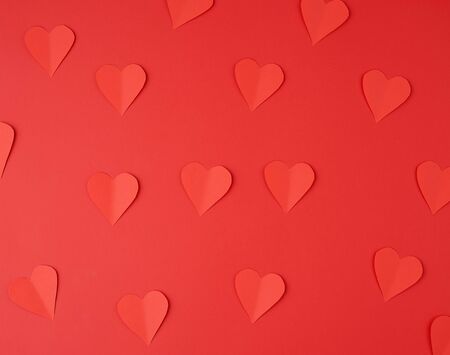 hearts cut out of red paper on a red background, festive backdrop for Valentine's Day, flat layの写真素材