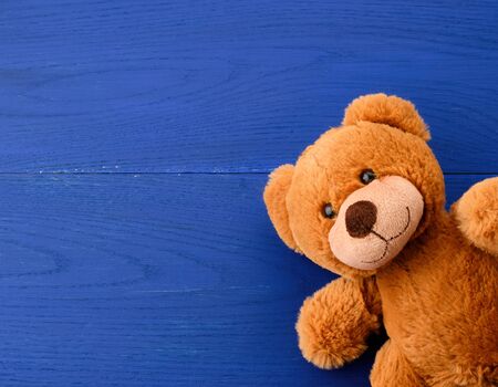 brown teddy bear on a blue wooden background, copy spaceの写真素材