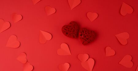 hearts cut out of red paper on a red background, festive backdrop for Valentine's Day, flat lay