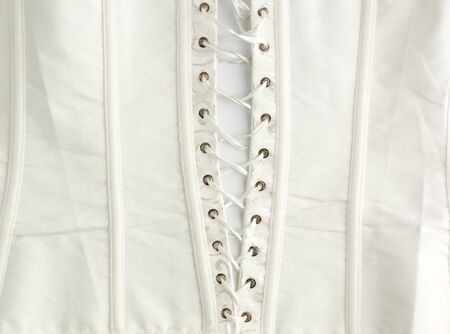 fragment of a white satin corset with lacing, wrong side of clothes