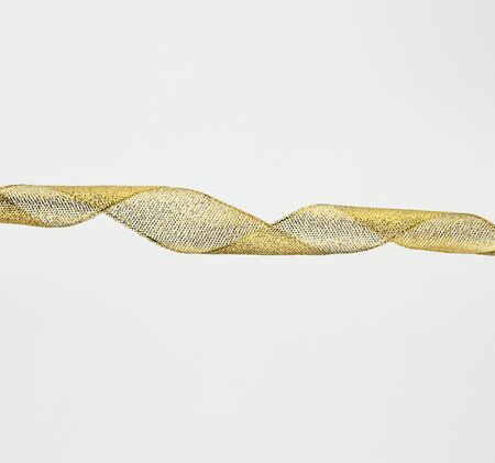 twisted golden silk decorative ribbon for packing gifts on a white background, close upの写真素材