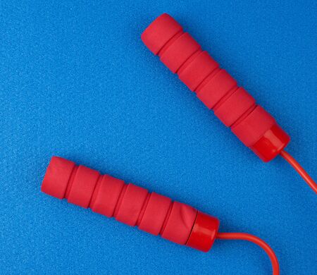 neoprene handles red rope lying on a blue neoprene sports matclose up