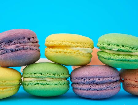 multi-colored round baked macarons cakes on a light blue background, close upの写真素材