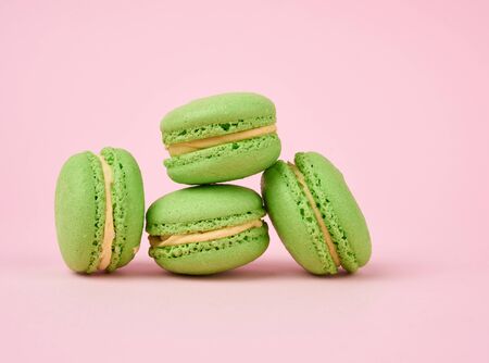 stack of green round almond flour cakes macarons with cream on a pink background, delicious cakeの写真素材