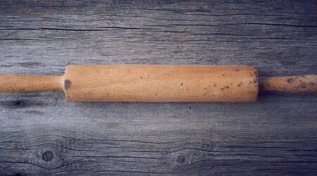 old wooden rolling pin on a gray wooden table, top viewの写真素材