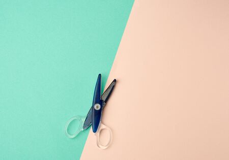 blue plastic paper scissors on a green-beige background, top view, flat layの写真素材