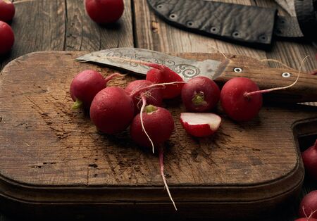 round red radish on a vintage kitchen board, gray wooden tableの写真素材
