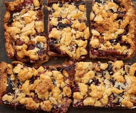 plum pie crumble on a brown wooden cutting board, top viewの写真素材