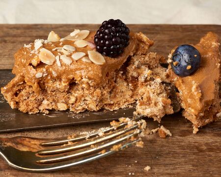 piece of meringue, baked egg white and butter cream cake decorated with blueberriesの写真素材