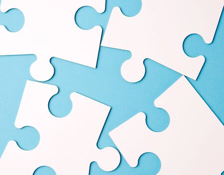 empty white big puzzles on a blue background. Concept in business, close upの写真素材