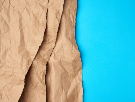 background of layered brown torn paper with a shadow on a blue background, backdrop and template for designer, copy spaceの写真素材