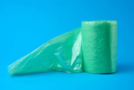 roll green plastic bags for trash bin on blue background, close upの写真素材