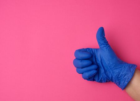 doctor in a white coat shows with his hand a gesture like, wearing blue latex medical gloves, close...