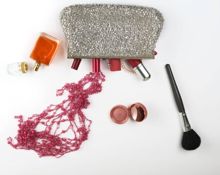 open silver cosmetic bag and women's cosmetics and perfumes, red lipstick, perfume on a white backgroundの写真素材