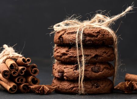 stack of round chocolate chip cookies tied with a rope on a black board, delicious dessert