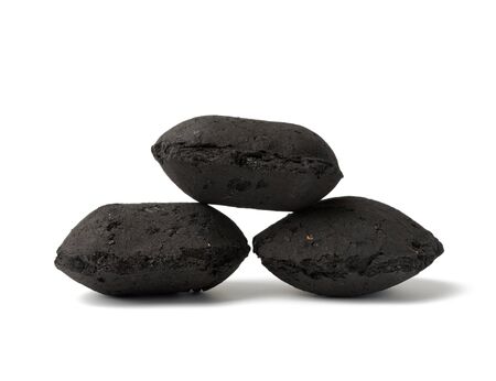 pile of black square briquettes of pressed charcoal for barbecue and bonfires, ecological fuel isolated on a white backgroundの写真素材