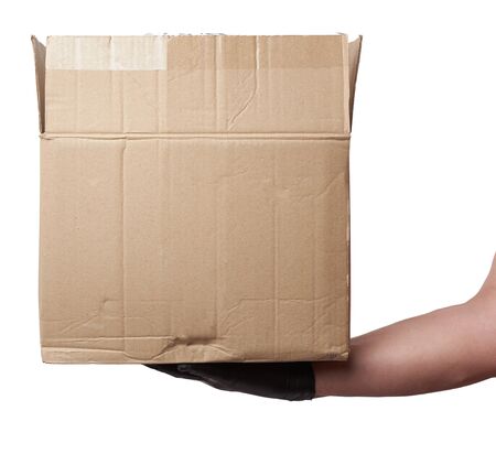 male hand in a black latex glove holds an open brown cardboard box on a white background, safe and contactless delivery of on-line orders during epidemicsの写真素材