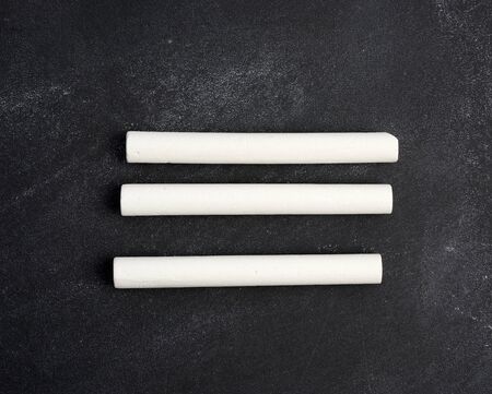 three white chalk on a blackboard, close upの写真素材
