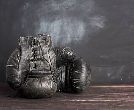 black leather vintage boxing gloves on a black background, sports equipment, copy spaceの写真素材