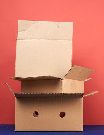 stack of cardboard boxes of brown kraft paper on a wooden table, moving conceptの写真素材