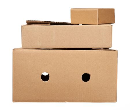 stack of closed cardboard brown paper boxes isolated on white backgroundの写真素材