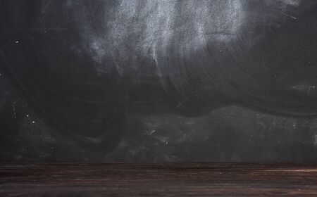 empty black chalk board and brown table, place for an inscription, close upの写真素材
