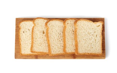 fresh bread made from white wheat flour is cut into slices on a wooden board, food is isolated on a...