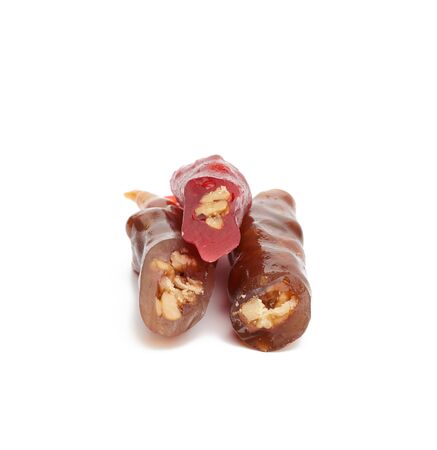Churchkhela is an ancient Georgian national sweet made from peeled nuts threaded in flour thickened juices: grape, pomegranate or other, sweet isolated on a white backgroundの写真素材