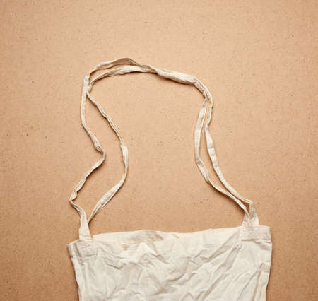 empty white textile reusable cotton shopping bag on brown background, top view, plastic rejection concept, zero wasteの写真素材