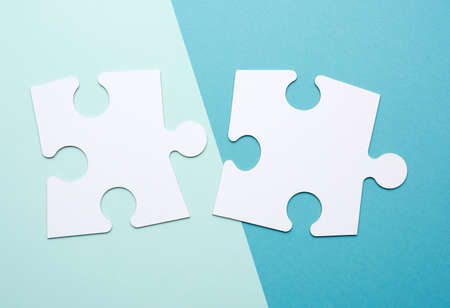 empty white big puzzles on a blue background. Concept in business, close up, flat lay