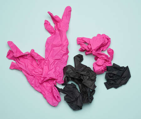black and pink latex gloves on a blue background, recyclable trash, top view
