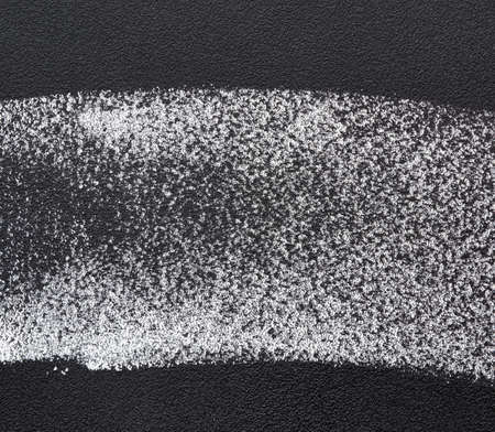 white chalk sample on a black chalk board, close upの写真素材