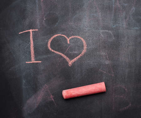 inscription in red chalk on a black chalk board, heart