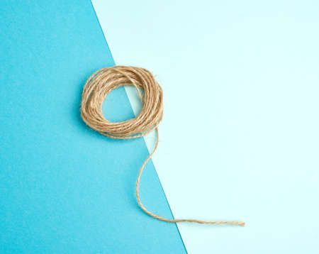 brown folded twine on a blue background, rope for household needs, top viewの写真素材