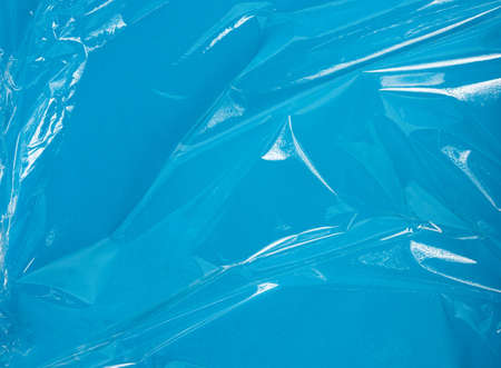 texture of a transparent stretching plastic film for packaging products on a blue background, full frame, close upの写真素材