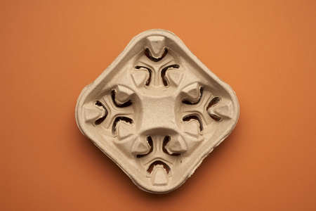 paper tray for drinks in takeaway cups on four cups on a brown background, top view