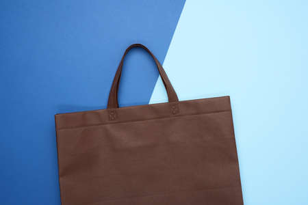 empty brown eco bag on blue background, rejection of plastic bags, flat lay, zero wasteの写真素材