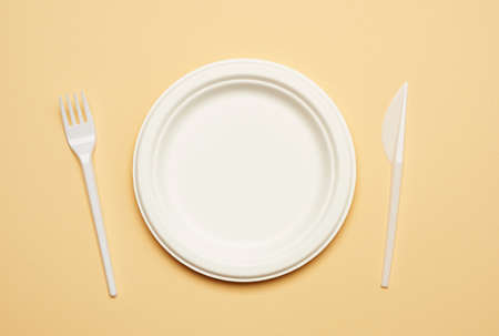 empty round brown disposable plate made from recycled materials on a beige background, top view. Concept of the absence of non-recyclable garbage, rejection of plasticの写真素材