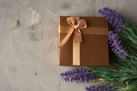 square gift box and lavender bouquet on gray background, top viewの写真素材