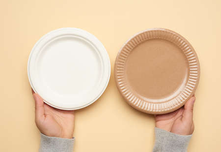 brown and white paper disposable plates on a beige background, top view. The concept of rejection of plastic, environmental conservationの写真素材