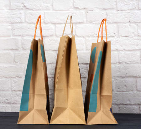 brown paper bag with handles on white brick wall background, environmental material, zero wasteの写真素材