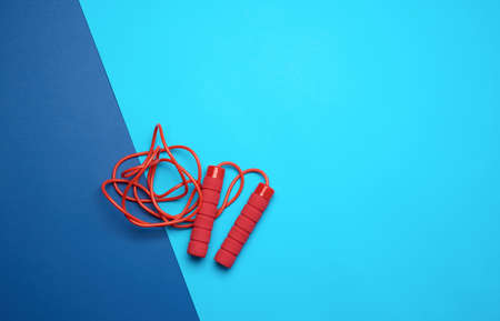 red rope for sports on a blue background, two neoprene handle, top view