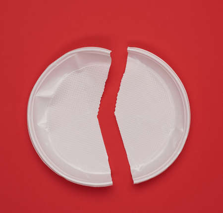 disposable white plastic plate on a red background, top viewの写真素材